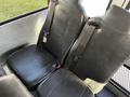 Two black leather seats with seatbelts designed for a school bus interior