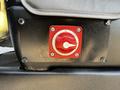 A red power switch with a circular dial labeled on and off mounted on a black surface of a Chevrolet Express van