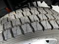 Close-up of a 2016 Ford F-550 tire displaying deep tread patterns and visible wear along the surface