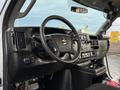 The interior of a 2019 Chevrolet Express features a steering wheel dashboard control panel and gear shift with a black finish and various buttons and knobs