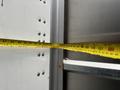 A measuring tape is extended inside a truck compartment showing various measurements with numerical markings