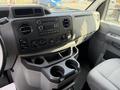 Interior view of a 2011 Ford Econoline featuring a dashboard with a stereo system air conditioning controls and cup holders