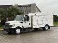 A 2014 International TerraStar truck with a white body featuring multiple access doors and a flatbed design