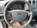 Steering wheel of a 2010 Ford Transit Connect featuring the Ford logo and controls on the side
