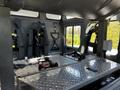 Interior of a 2006 Emergency One Fire Truck featuring metal seats and safety harnesses on a diamond plate floor