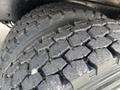 Close-up of the tread on two large tires typically used on a 1998 Freightliner FL80 showcasing their rugged design and detailed patterns