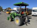A 2008 John Deere 3320 300X tractor featuring large rear tires a green and yellow color scheme and a canopy for shade