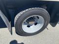 A close-up view of the wheel and tire of a 2015 Ford F-450 SD showing the black tire and silver rim with multiple holes