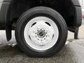 Close-up of a white wheel and tire of a 2022 Ford F-550 featuring a multi-spoke design and a rugged tire tread pattern