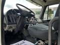 Interior of a 2010 Freightliner M2 106 featuring the driver's seat steering wheel and dashboard controls