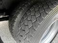 Close-up of a tire on a 2015 Mitsubishi Fuso FE showing rugged tread patterns and visible wear on the rubber surface