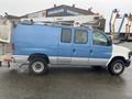 A 2009 Ford Econoline van with a blue and white exterior featuring an elevated work platform attached to the roof