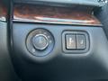 A close-up of a control panel featuring a circular dial for lights and a rectangular button for seat adjustments in a 2013 Lincoln MKT