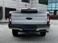 A silver 2017 Ford F-250 pickup truck viewed from the rear showing the tailgate with the Ford logo and the Super Duty label