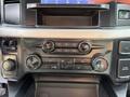 Dashboard controls of a 2023 Ford F-550 featuring air conditioning settings and audio system buttons