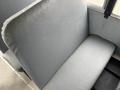 A gray bench seat in a school bus with a smooth surface and simple design focusing on functionality