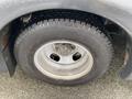 Close-up of a wet tire on a silver wheel from a 2017 Chevrolet Express with visible tread patterns and metal center hub