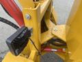 A close-up view of a yellow and red 2024 AGT KRW 23 Mini loader showcasing its hydraulic components and control mechanisms