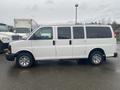 A white 2012 Chevrolet Express van with a square body and chrome wheels parked in a lot