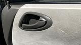 Close-up of a Honda Fit door handle with a textured fabric covering and a grayish-colored pull handle