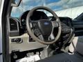 Interior view of a 2018 Ford F-550 featuring a black steering wheel with a Ford logo and control buttons alongside a dashboard with various controls and displays