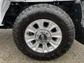 Close-up of a silver wheel and tire of a 2020 Ford F-350 SD with aggressive tread pattern and chrome accents on the wheel rim