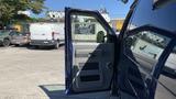 A 2013 Ford Econoline van with its side door open revealing the interior details and seating