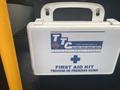 A first aid kit mounted on the interior of a 2016 International 7400 truck with bilingual text indicating its purpose in English and French