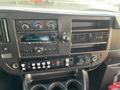 Dashboard of a 2018 Chevrolet Express featuring a radio display climate controls and various switches with cup holders below