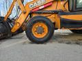 A close-up of the front tire of a 2015 Case 590SN construction vehicle showcasing the tread and rim details