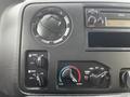 Control panel of a 2016 Ford Econoline featuring climate control knobs an audio system and a digital display