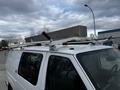 A 2011 Ford Econoline van with a ladder rack on the roof featuring two red grips and a clear light on the front