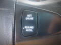 Close-up of a control panel featuring buttons labeled Set/Cruise and Resume/Accel on a black textured surface