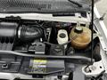 Image shows the engine compartment of a 2009 Ford Econoline with various components visible including the air intake hose coolant reservoir and engine parts