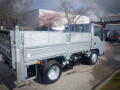 A gray 2008 Isuzu Elf flatbed truck parked with a simple design and visible cargo area