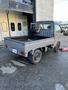 A 2000 Daihatsu Hijet being worked on with a person adjusting the interior of the truck bed