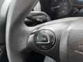 Close-up of a steering wheel with control buttons including a circular OK button and arrow buttons for navigation on a 2016 Ford Transit Connect