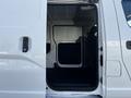 A 2017 Nissan NV200 with its side door open revealing the empty cargo space and front seat area