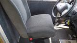 A gray upholstered driver's seat of a 2011 Ford Econoline with a steering wheel and keys hanging from the ignition