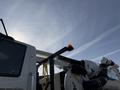 A 2013 International 7400 truck with a mounted boom arm and an orange warning light on top