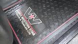 A black rubber floor mat featuring the logo of James Western Star Truck and Trailer Ltd with a hexagonal pattern and a red outline