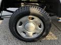 A close-up of a silver wheel with a black tire labeled Road Venture AT61 featuring a textured tread pattern and a circular hubcap