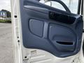 The interior door panel of a 2006 Hino 268 featuring a blue plastic finish with various controls and a handle for opening the door