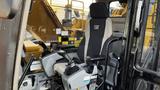 A 2018 Caterpillar 326F L Excavator operator's seat with control joysticks and armrests visible in the cabin