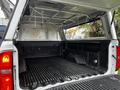 A 2018 Chevrolet Colorado truck bed with a hard top cover open showing a lined cargo area and storage space with no items inside