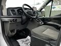 Interior of a 2021 Ford Transit featuring a driver's seat dashboard and control panel with a modern design and a displayed thank you note on the floor mat