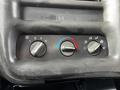 Dashboard control panel of a 2006 GMC C5000 with three knobs for fan speed temperature and air distribution settings