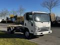 A 2017 Isuzu NQR truck with a bare chassis and no cargo bed parked at the side of the road