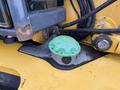 Close-up of a green fuel cap on the engine compartment of a 2011 John Deere 310SJ 4x4 Wheel Loader with extended hoe and 4 in 1 bucket