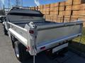 A 2008 Ford F-450 SD with a metallic silver dump bed and a black tarpaulin cover on the cab